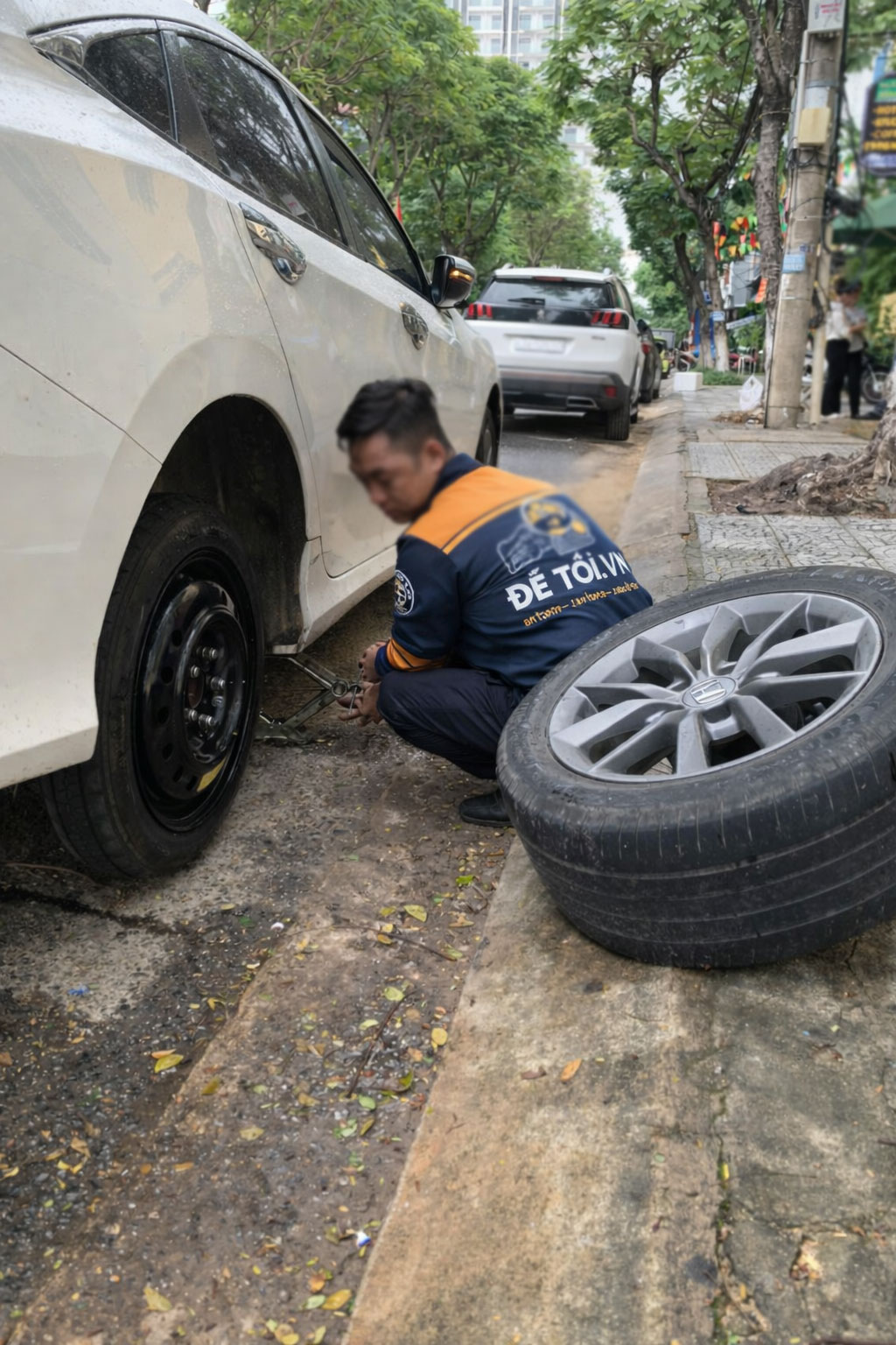 Thợ sửa ô tô đang thực hiện thay thế lốp dự phòng